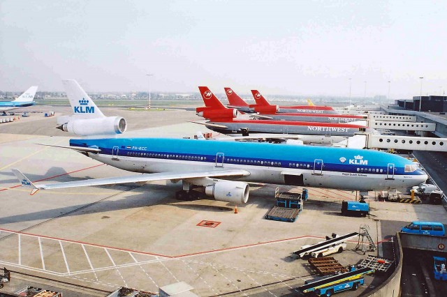 KLM MD-11 at AMS with Northwest DC-10s in the background. Image taken in 2001 by Ken Fielding. 
