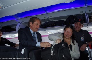 Virgin America President/CEO helps load a passengers bag into the overhead bins at SFO