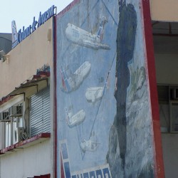 Fidel Castro, in full military garb, is painted posing with Cubana’s old Russian fleet in this mural on a wall of the airline’s maintenance base at HAV. Photo by Chris Sloan.