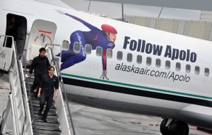 Apolo Alaska Apolo Ohno getting off the plane with his face on the side.