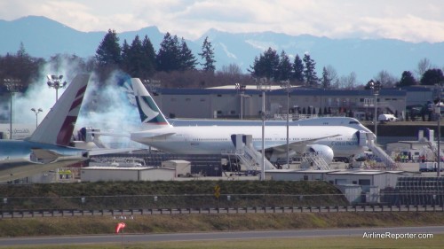 Boeing 747-8 engine smoke from the start up, partly blocked by a new Boeing 777