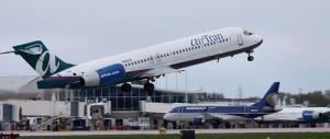 AirTran Boeing 717 taking off while Midwest sits in the background