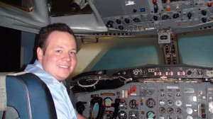 Me inside the cockpit of the Boeing 727 with all the buttons and lights.