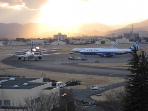 A United Boeing 747-400 and American Airlines Boeing 777 sit while other aircraft start to line up.