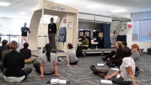 Class of new flight attendants learning how to open and close the main cabin door.