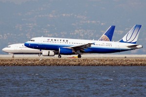 A United Airlines A320-200 lands while a Continental Boeing 737 is in the background.