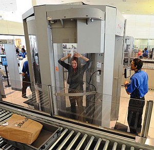 A passenger gets scanned in a body scanner. 