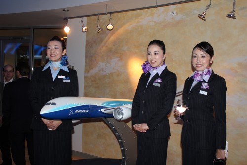ANA flight attendants pose in front of a large 787 model at the Dreamliner Gallery.
