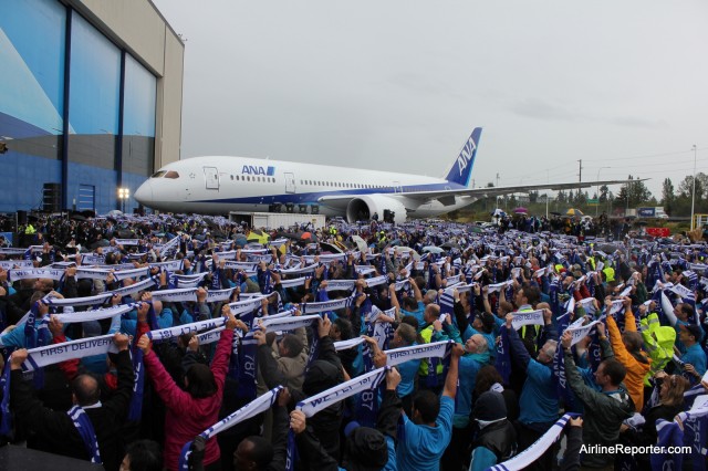 Scarfs were handed out and then raised in celebration during the 787 Delivery event. A 787 (ZA002) looks on. 