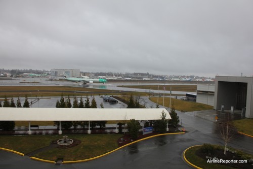 An Emirates Boeing 777-300ER prepares to take off a Paine Field. Taken from the room. That is the Future of Flight on the right.