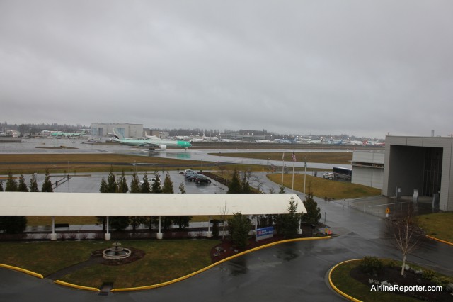 An Emirates Boeing 777-300ER prepares to take off a Paine Field. Taken from the room. That is the Future of Flight on the right. 