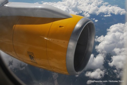 Icelandair's yellow nacelle with mountains in the background.