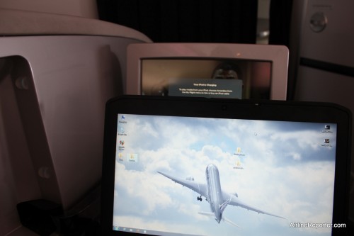 A larger laptop on the tray table gets in the way of the entertainment screen.