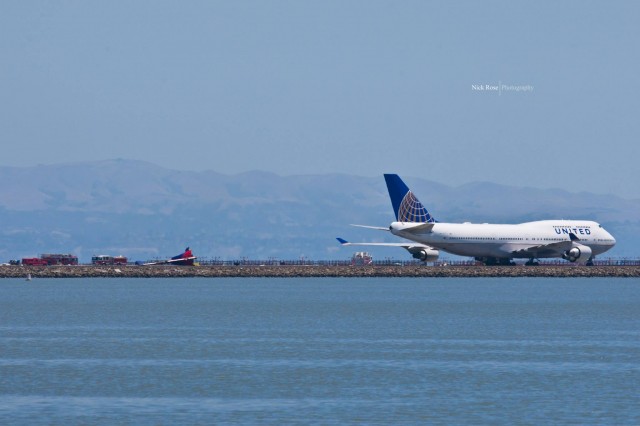 Parts of the 777 on the field while the United 747 waits. Photo by Nick Rose. 