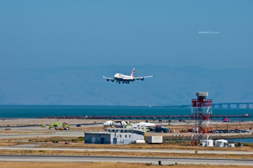 A British Airways Boeing 747-400 lands while the Asiana Airlines 777 sits. Photo by Nick Rose.