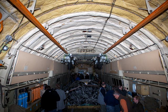 The cargo hold of an Air Koryo IL-76 featuring both rice and passengers.