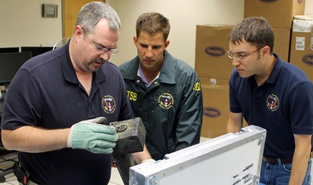 Investigators conducting initial examination of one of the recorders from UPS flight 1354 in the NTSB laboratory. 