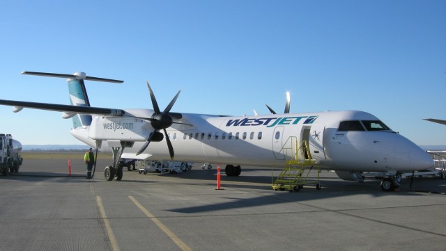Westjet Encore Bombardier Q400 C-FENY at North Peace Regional Airport (YXJ) in Ft. St. John BC, under a beautiful blue sky.