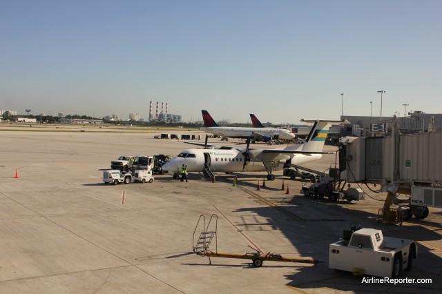 How many Dash 8's does it take to replace a Boeing 737? Two. The first one wasn't as colorful as the second (this is the 1st). Notice the air stairs going up to the jetway.  