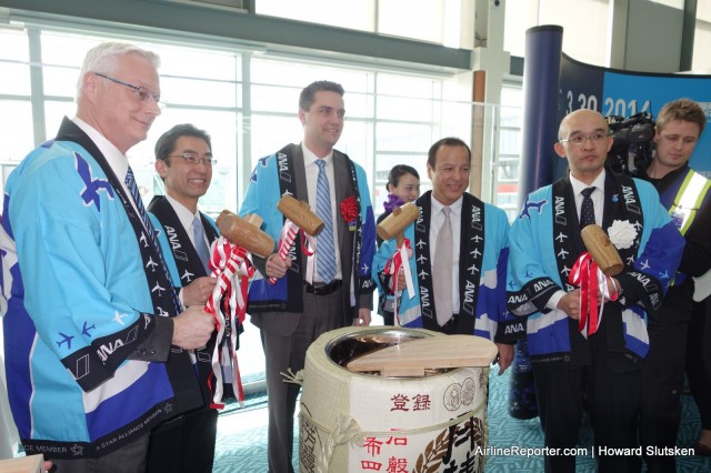 Inaugural flight dignitaries smash open the ceremonial barrel of sake. Photo: Howard Slutsken