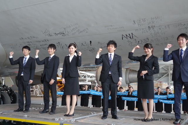 Enthusiastic new ANA employees sign the fuselage of ANA's last 747-400D after its final flight.