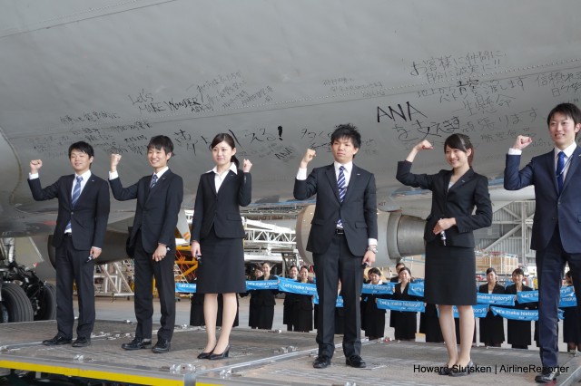 Enthusiastic new ANA employees sign the fuselage of ANA's last 747-400D after its final flight.