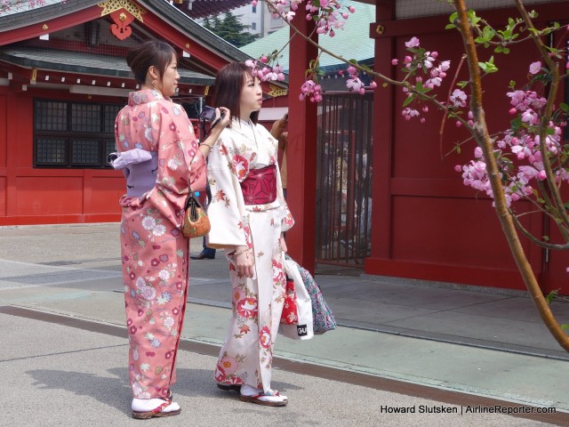 Two kimono-clad visitors to the SensÅ-ji Temple appreciate a sakura (cherry blossom).