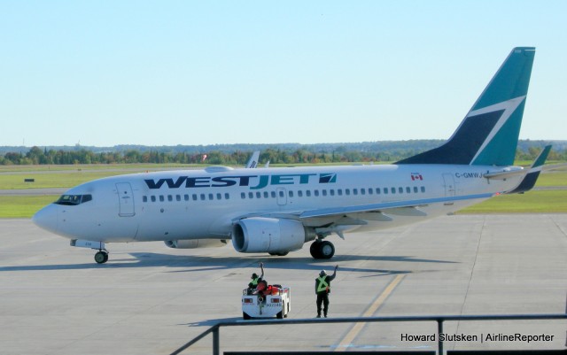 Westjet "rampies" wave goodbye to the passengers after a quick turnaround at Ottawa YOW.