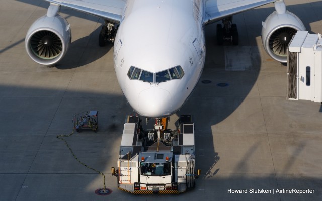 A wheel-lift tug ready to move an empty ANA 777 at Tokyo-Haneda. Look for the "remove before flight" banner and pin on the nosegear.