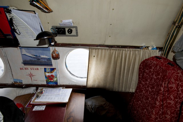 The crew rest "Business Class" area of an AN-12 operated by RubyStar Airlines. The chairs face a table so you can face forwards or backwards. Photo - Bernie Leighton | AirlineReporter.com 