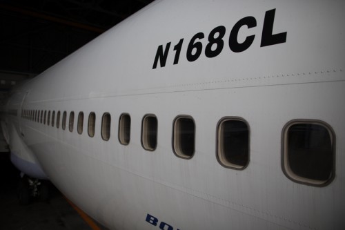 The rear fuselage of a Boeing 747 is seen in the hangar, with a curious American registration.