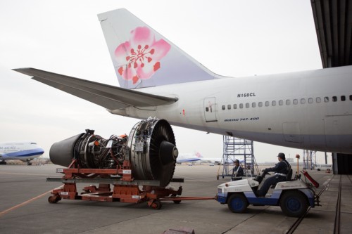 An engine is shuffled around outside the hangar, ready to be placed back on a jet.