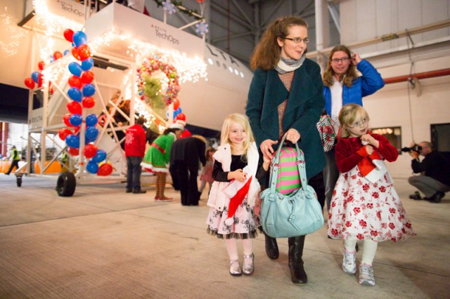 The flight complete, families deboard the jet into a Delta hangar / North Pole for an evening of games, gifts, and surprises.