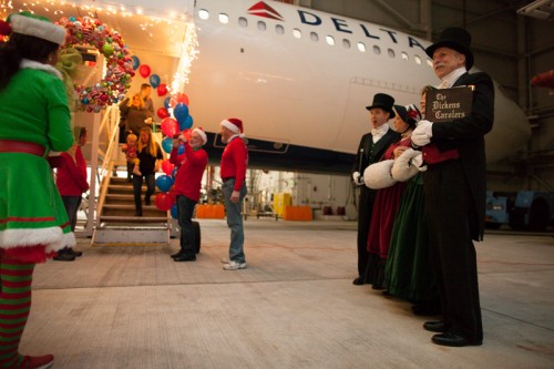 Carollers greet families as they deboard the jet.
