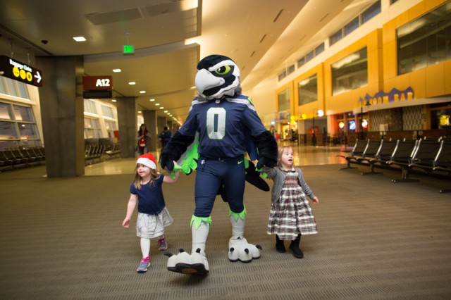 Seattle Seahawks mascot Blitz escorts two children to gate A13 in SeaTac Airport for their Delta flight to the North Pole.