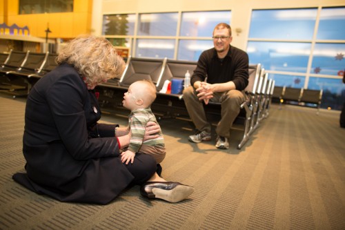 One-year old Sebastian, from West Seattle, enjoys a moment with a crew member with his father Bernd looks on.