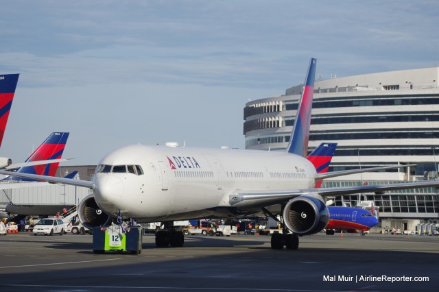 The 767-400ER with the Seattle Seahawks onboard Pushes back by a specially painted Tug - Photo: Mal Muir | AirlineReporter.com