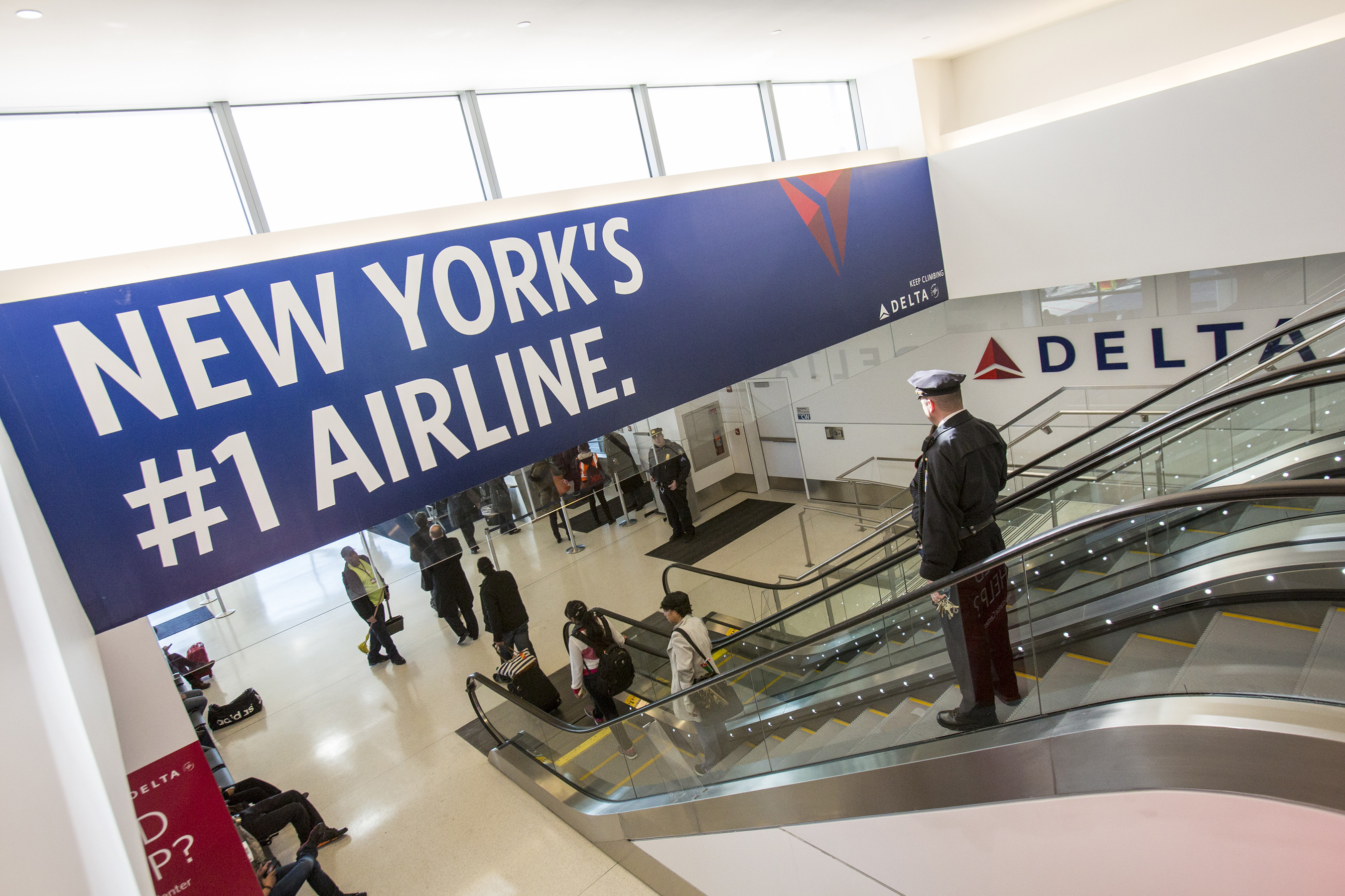 A Delta pilot makes his way to one of the new gates as Delta Air Lines, unveiled the next phase of a Terminal 4 expansion at JFK - Photo: Michelle McLoughlin | Newscast Creative