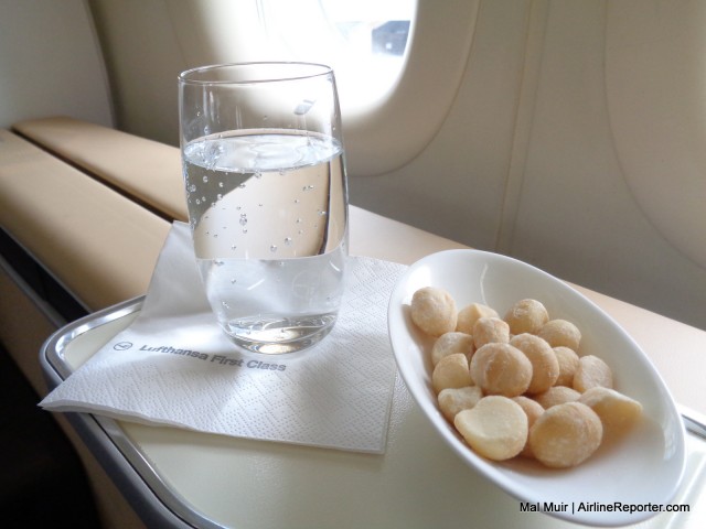 The Signature Pre Departure Beverage service for Lufthansa first class.  Your choice of beverage served with Macadamia (Queensland) nuts.