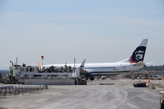 An Alaska Airlines 737-800 crosses 16C/34C, while a concrete pouring machine is in place, ready for the next panel. - Photo: Lauren Darnielle | AirlineReporter