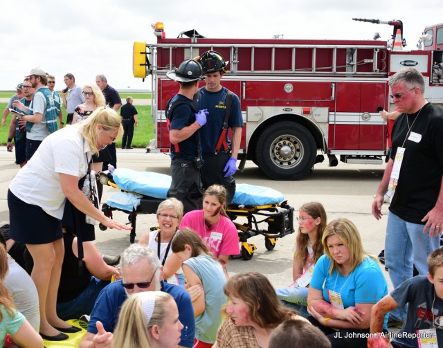 A flight attendant and first-responders move on to tend to those with less severe wounds.  