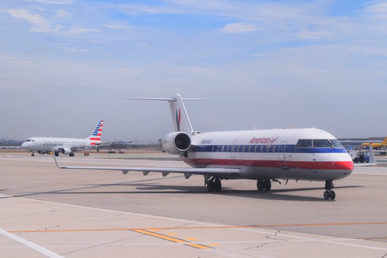 An American Eagle CRJ-200 taxiing at LAX, with a new Embraer 175 following. Photo: John Nguyen | AirlineReporter