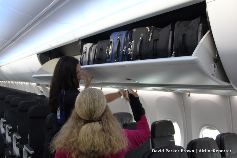 Harriet Baskas and flight attendant Jenn-Marie check out the new Space Bins