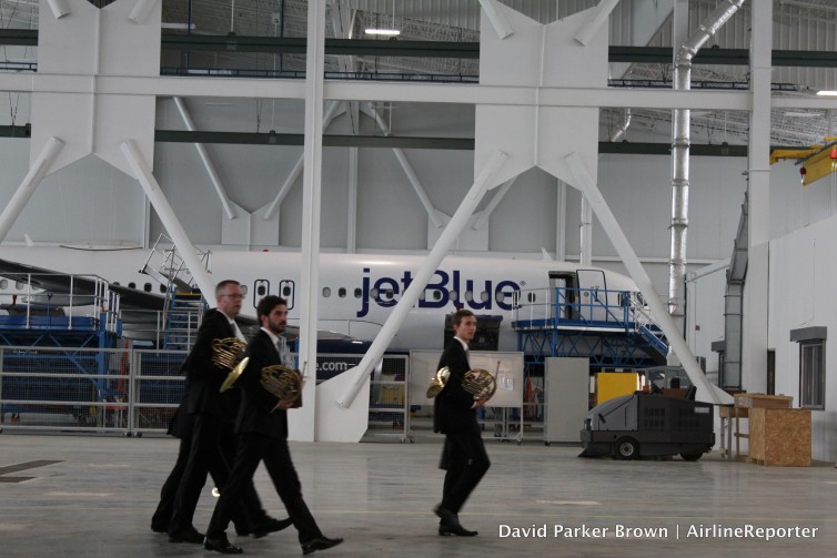 Orchestra members walk by the JetBlue A320