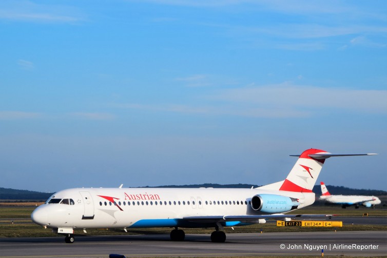 OE-LVB, an Austrian Airlines Fokker 100 taxiing at VIE, with an Airbus A320 off in the distance.