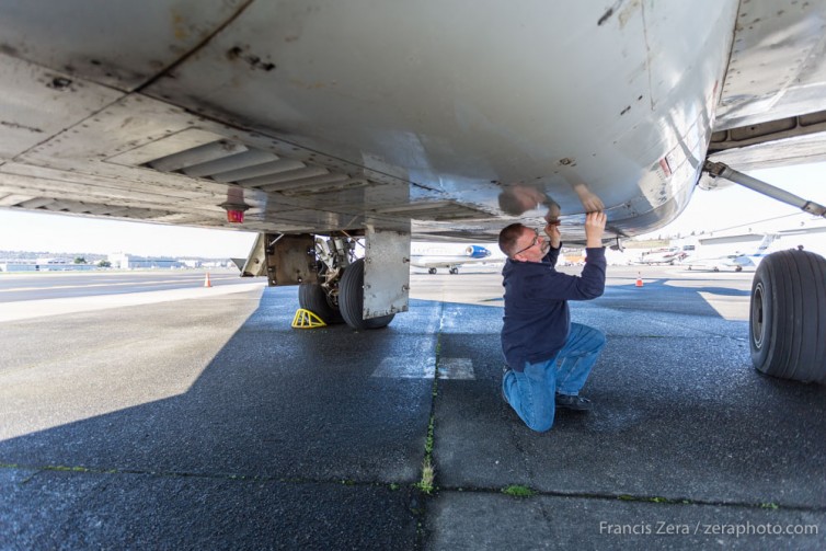 NAHM CEO John Roper secures access panels while inspecting his museum's newly-acquired B727 at Boeing Field in Seattle.