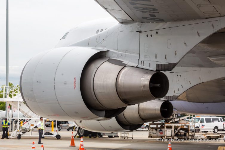 A ramp worker is dwarfed by the 747-400F's massive engines.