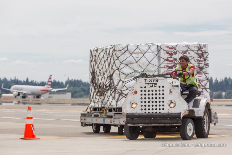 A tug hauls a pallet of cherries to a waiting freighter.