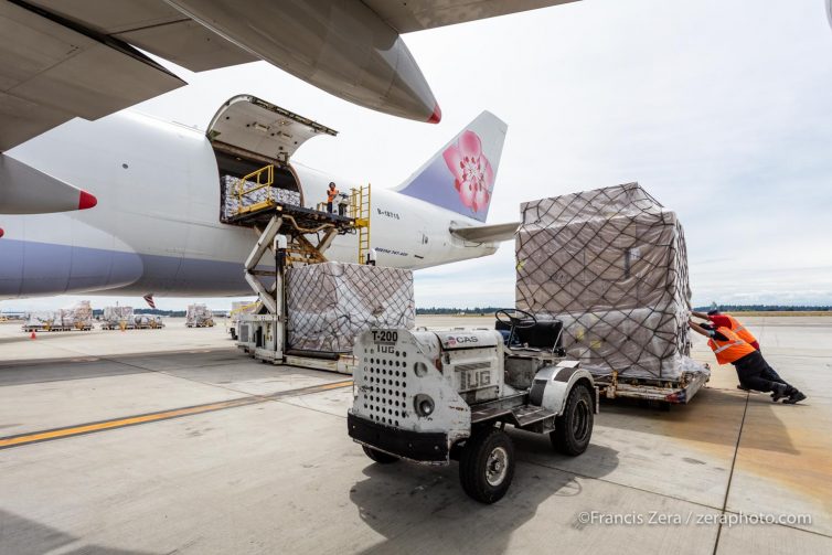 Sea-Tac Airport cargo workers push a pallet of freight onto the loading ramp of an Air China Cargo 747-400F.