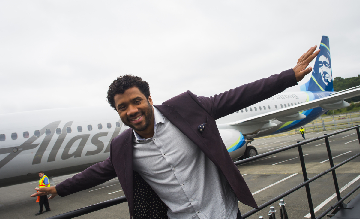 Seattle Seahawks quarterback Russell Wilson poses in front of the 737 - Photo: Alaska Airlines